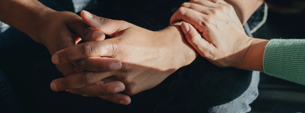 Photo of hands with consoling one another.