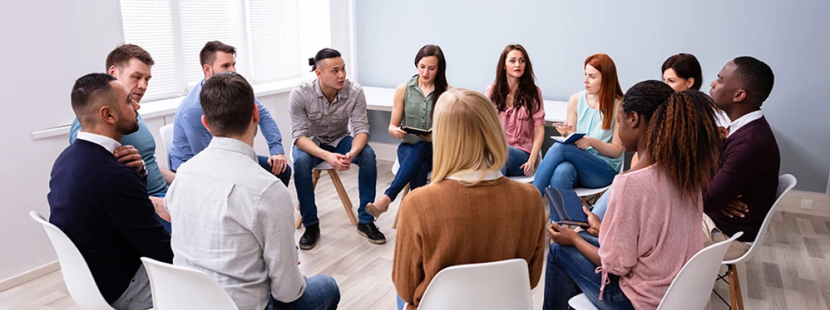 Young Multiracial Millennial Friends Sitting In Circle Having Group Discussion